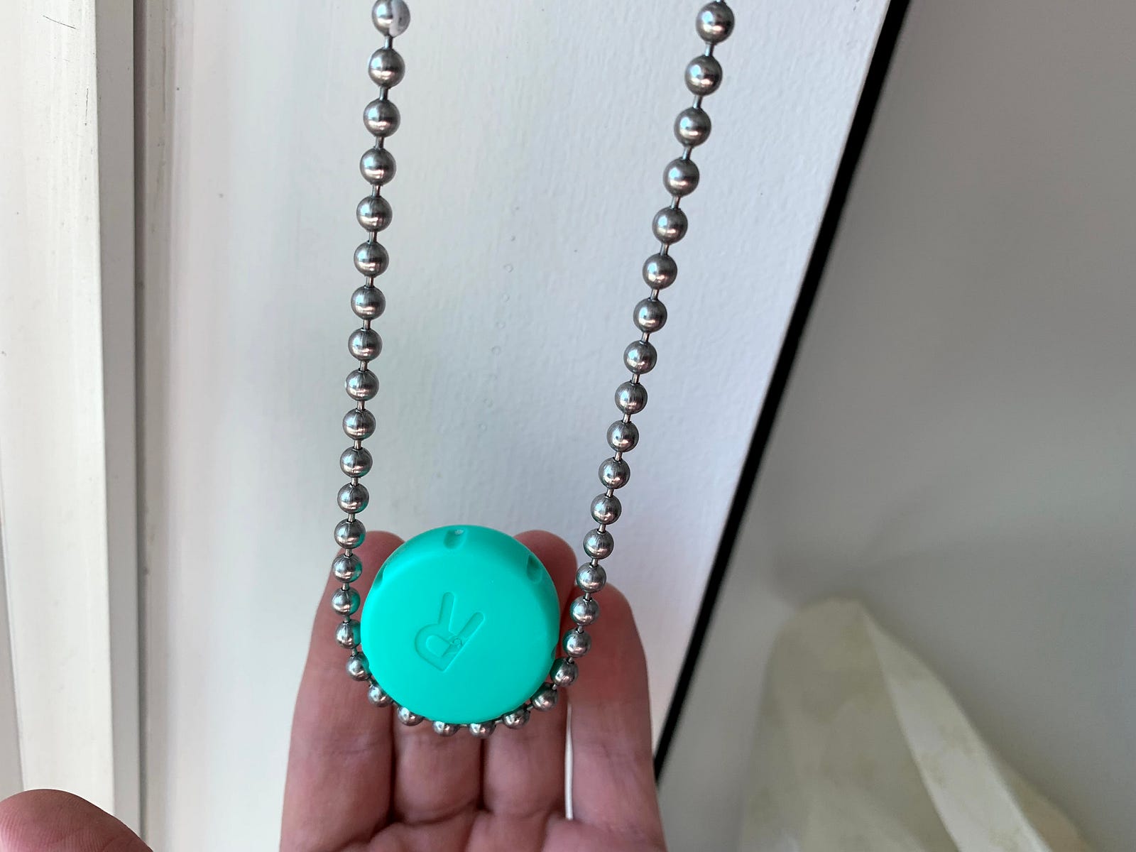 Beaded shade chain wrapped around a contact-lens cap for scale